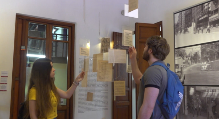 Dos jóvenes miran material de archivo.