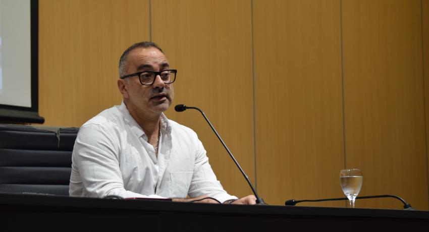 Foto. Federico Beltramelli tras ser designado como decano de la FIC. Beltramelli habla a los claustristas desde el estrado del aula magna. 