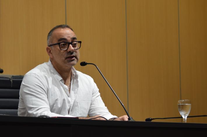 Foto. Federico Beltramelli tras ser designado como decano de la FIC. Beltramelli habla a los claustristas desde el estrado del aula magna. 